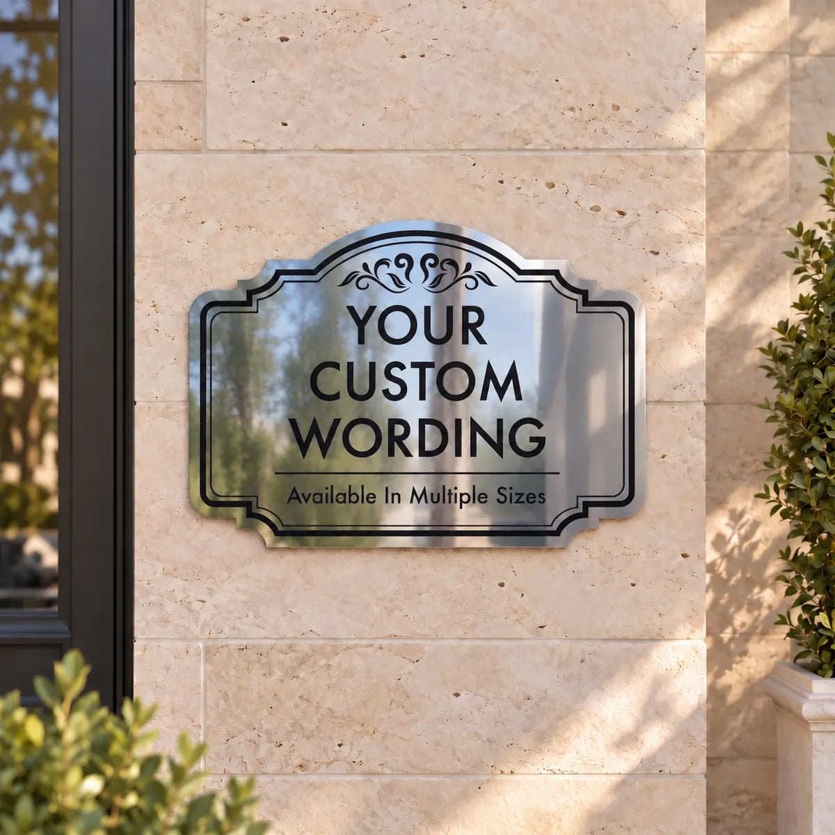 Ornate mirror finish business sign with custom black lettering mounted on a limestone storefront wall