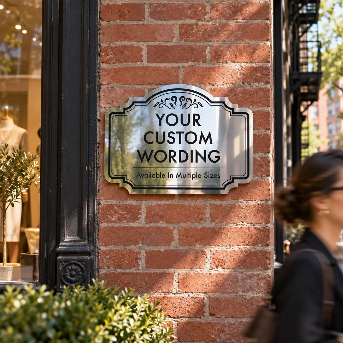 Custom mirror finish aluminum sign mounted on a red brick boutique facade
