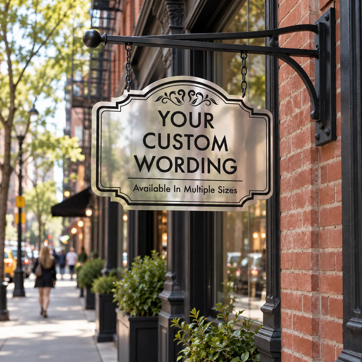Double-sided hanging blade sign in mirror finish aluminum projecting from a brick building on a city street