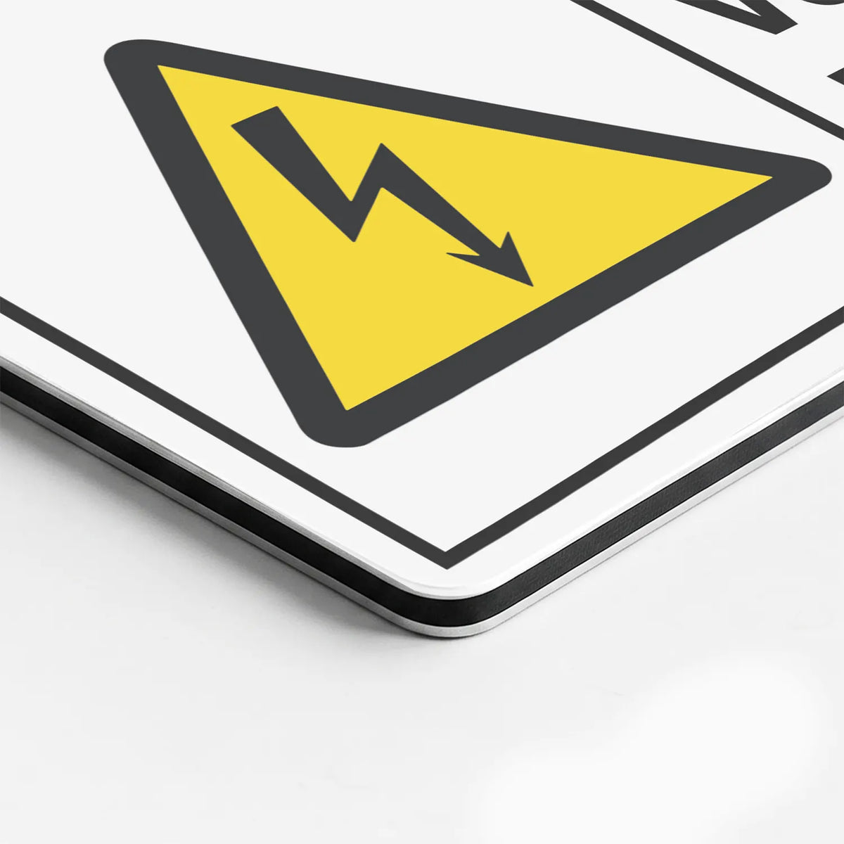 Close-up of the Hazardous Voltage Keep Away sign's printed surface and rounded edge
