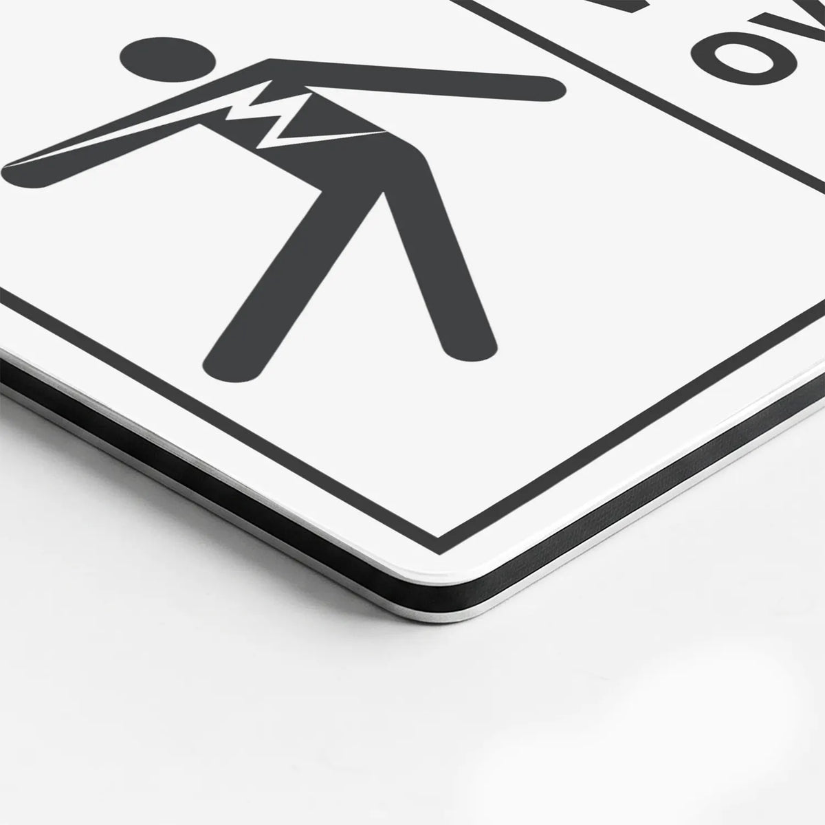 Close-up of the Hazardous Voltage Overhead Keep Away sign's printed surface and rounded edge