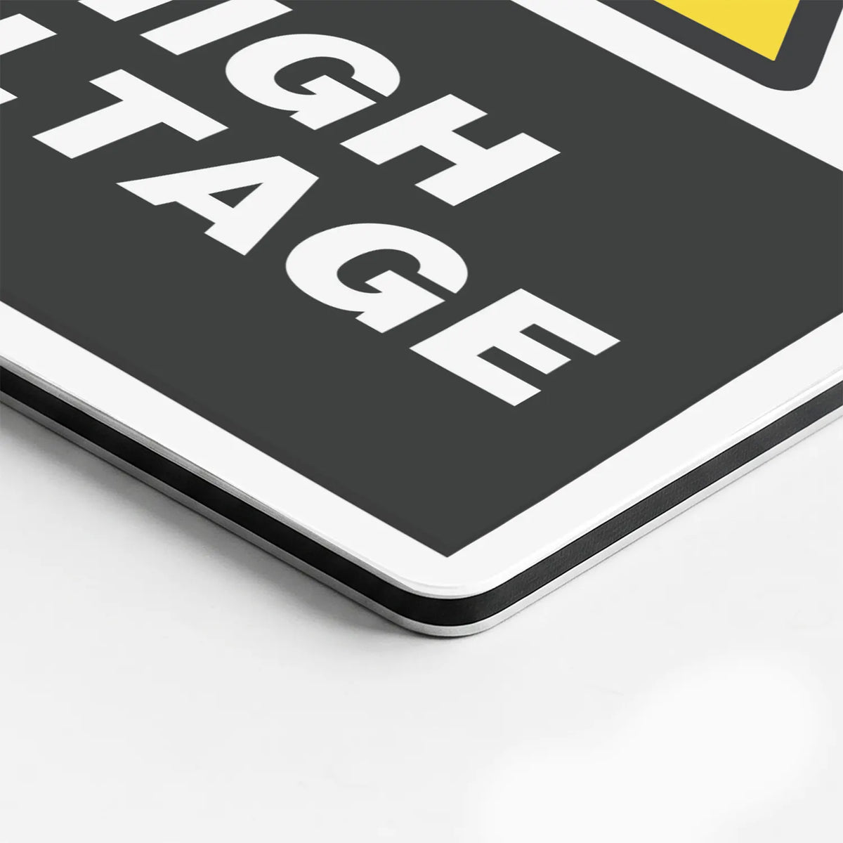 Close-up of the High Voltage sign's printed surface and rounded edge