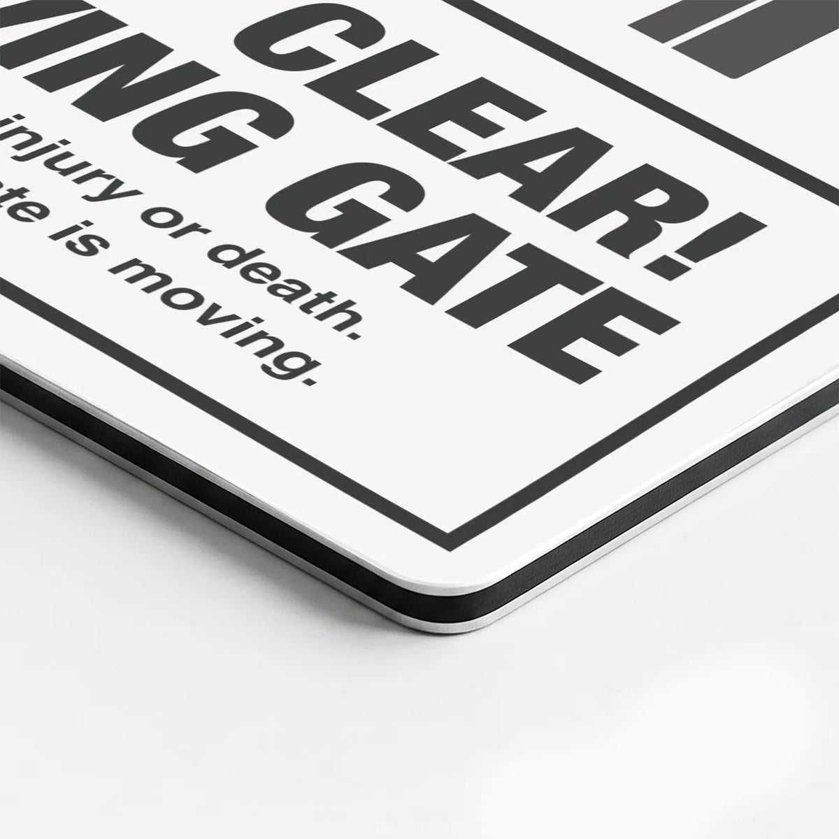 Close-up of the Keep Clear Moving Gate sign's printed surface and rounded edge